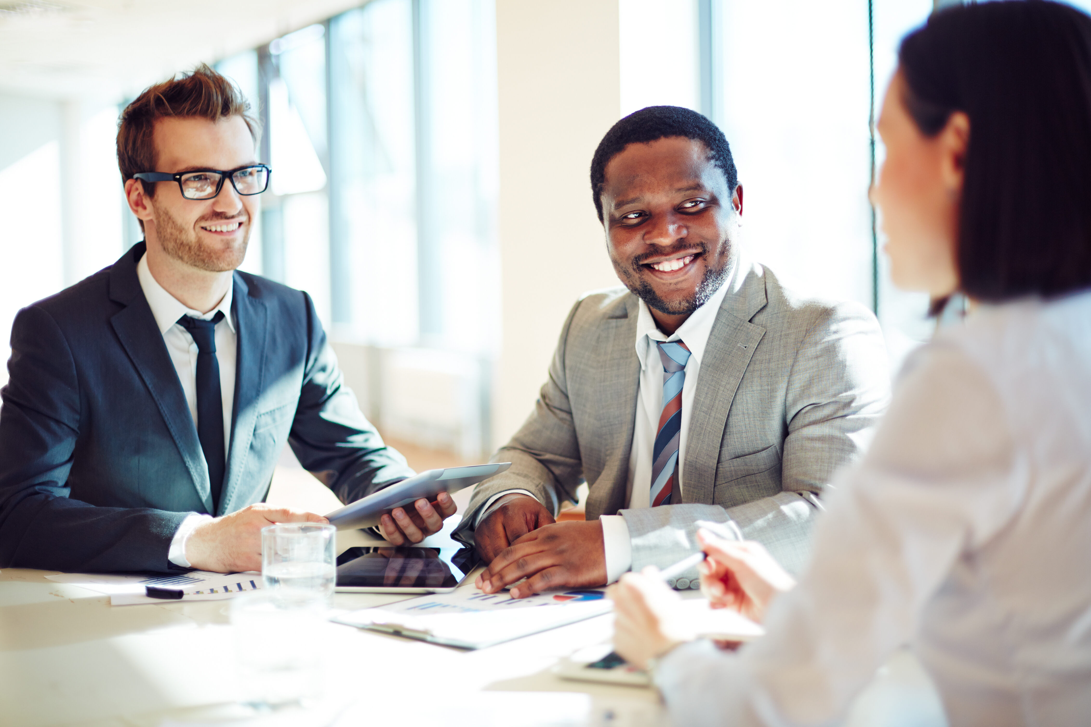 Smiling businessmen listening to young female during interview