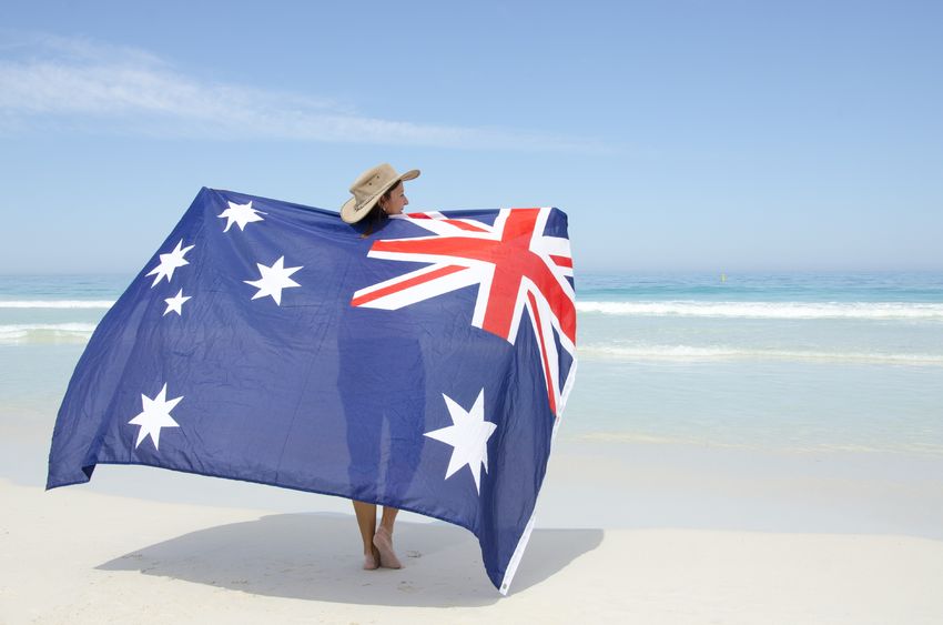 Person carrying Aussie flag on the beach